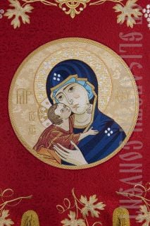red brocade khorugv decorated with embroidery and an icon of theotokos