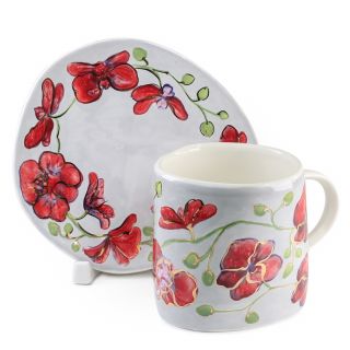 ceramic cup and a saucer with red orchids