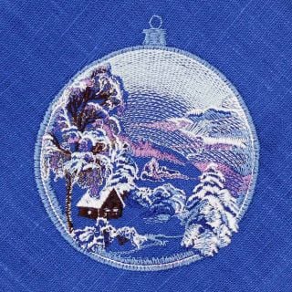 blue linen table napkin with embroidered winter scenery in a tree bauble
