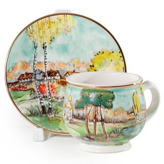 handmade ceramic coffee cup and saucer with a church in woods in autumn