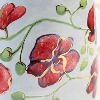 ceramic cup and a saucer with red orchids