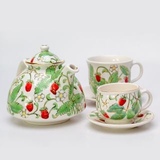 ceramic tea set with a teapot and cup and a saucer set with strawberries