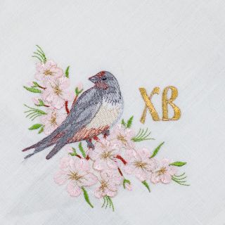 paschal red linen kitchen napkin with embroidered birds and cherry tree in blossom
