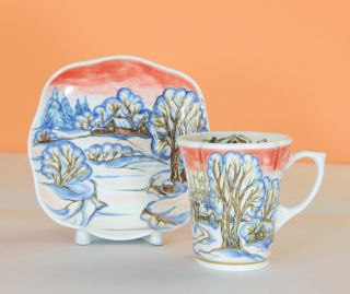 ceramic cup and a saucer set with red sky in winter landscape