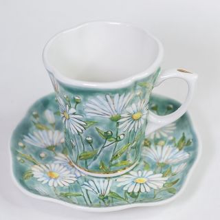 Cup and a saucer with painted white chamomiles