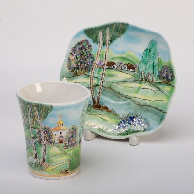 ceramic cup and a saucer set hand-painted and decorated with gold elements